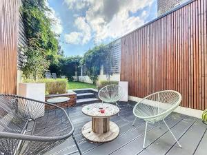 a patio with two chairs and a table on a deck at Maison de ville avec Jardin in Saint-Quentin