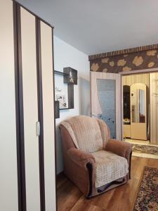 a living room with a chair and a mirror at Modern Beach Apartment in Constanţa