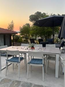 a table with chairs and an umbrella on a patio at Five shades of blue in Vourvourou