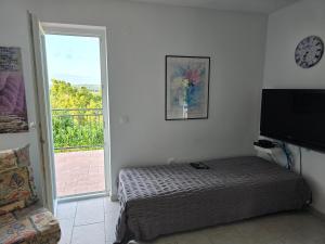 a bedroom with a bed and a clock on the wall at Apartman Ivy in Premantura