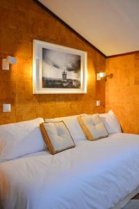 a bedroom with two white beds with a picture on the wall at Casa Azul - 2min walk to the Beach, in the Historical Center of Sesimbra in Sesimbra