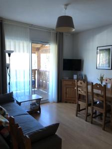 una sala de estar con un sofá y una mesa en T2 tout confort Ax les thermes, en Ax-les-Thermes