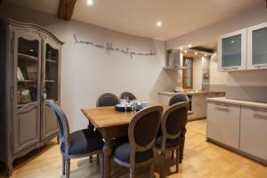 a kitchen and dining room with a wooden table and chairs at Appartement Bredala avec Climatisation in Colmar