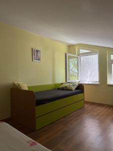 Un dormitorio con una cama en una habitación con ventana. en Villa Ela, en Prijedor