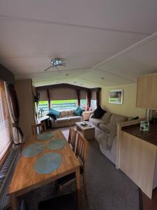 an rv living room with a table and a couch at Moselle - 6 Squirrel View in Ballantrae +18 photos