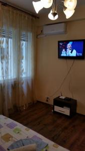 a bedroom with a tv on the wall and a bed at Studio Victoriei in Bucharest