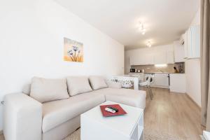 a white living room with a white couch and a table at Copacabacum Sea View in Varna City