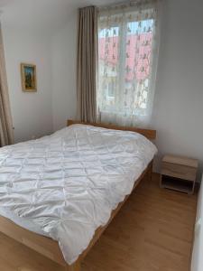 a white bed in a bedroom with a window at The Urban Hero Appartment in Floreşti