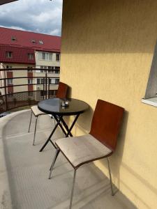 two chairs and a table on a balcony at The Urban Hero Appartment in Floreşti