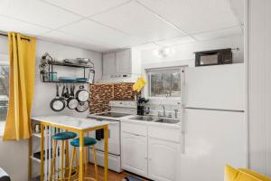 a kitchen with white cabinets and a white refrigerator at Nothing Fancy Older Apt Walk to Downtown King Bed in Dover