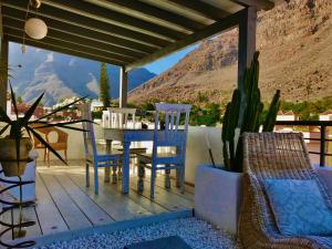 un patio con mesa, sillas y una montaña en Penthouse Valle Gran Rey, en Valle Gran Rey