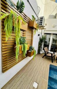 a patio with plants on a wooden wall at DARZAYNAH in Monastir