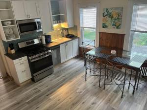a kitchen with a table and a stove top oven at Beverly, Salem, Dwtn, Water and Train in Beverly