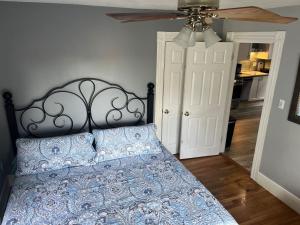 a bedroom with a bed with a blue comforter at Beverly, Salem, Dwtn, Water and Train in Beverly