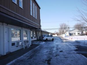 un coche aparcado frente a un edificio en Motel Rive Du Lac, en Saint-Zotique