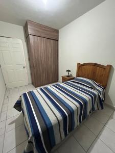 a bedroom with a bed with a blue and white striped blanket at Confortable casa al norte de Saltillo in Saltillo +18 photos