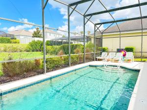 a swimming pool with two chairs in a house at 5 bedrooms pool home Calabay in Davenport