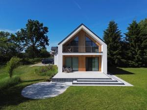a house on a hill with a porch and stairs at Odpoczynek na wsi in Koskowo