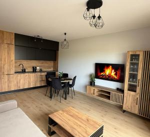 a living room with a table and a fireplace at Słoneczny Apartament Karpicko in Karpicko