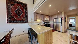 a large kitchen with a counter and a refrigerator at Comfortable 4 Bedroom Condo in Mammoth Lakes