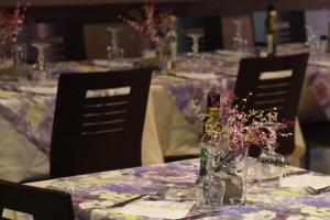 a table with purple table cloth and chairs with flowers at Hotel Alaska in Rimini