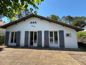 a white building with blue doors and windows at Villa EtcheOna in Soorts-Hossegor