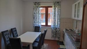 a kitchen with a table and chairs and a window at Apartment Merak II in Sarajevo