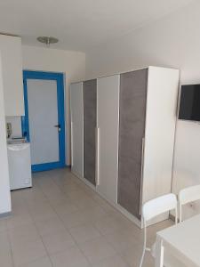 a kitchen with white cabinets and a blue door at Grazioso Monolocale ristrutturato a due passi dal mare in Marotta