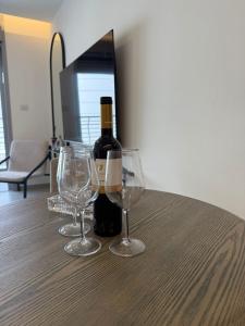 a bottle of wine and two wine glasses on a table at oR-Ya Suite- U360 in Eilat +4 photos