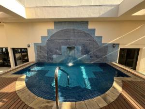 a swimming pool with a fountain in a building at Apto Ninet Jardins Lorena 1301 in Sao Paulo