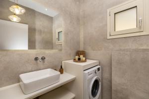 un bagno con lavatrice e lavandino di Vera Villa - Brand New Seafront Villa! a Alykes Altre 55 foto