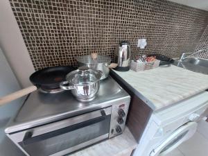 a kitchen with a stove with a pot on it at The Mastiha Spot 3 in Chios +22 photos