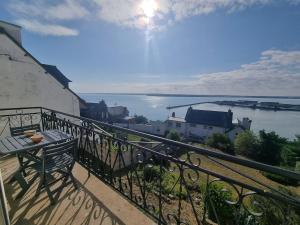 a balcony with a bench and a view of the water at House for 4 people with a breathtaking view in Plérin