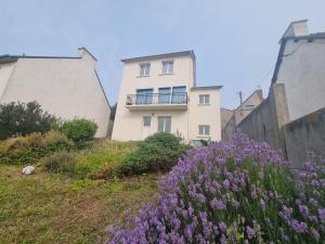 a white house with purple flowers in front of it at House for 4 people with a breathtaking view in Plérin +8 photos