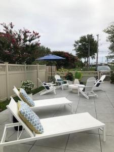 un grupo de sillas y mesas y una sombrilla en Salisbury street 207, en Rehoboth Beach