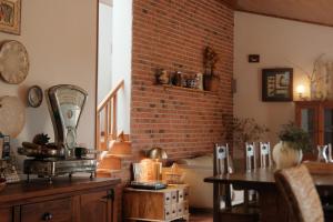a living room with a brick wall and a table at Quinta Amarela - B&B in Nazaré