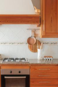 a kitchen with a stove and wooden cabinets at Quinta Amarela - B&B in Nazaré