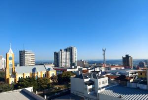 a city skyline with tall buildings and a church at Hotel Ponta Grossa São Marcos in Ponta Grossa