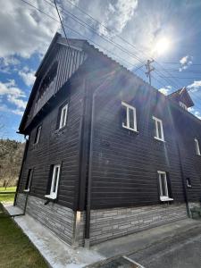ein schwarzes Haus mit weißen Fenstern an der Seite in der Unterkunft Traditionelles Haus in Trieben