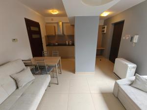 a living room with a couch and a table and a kitchen at apartamenty sarbinowo in Sarbinowo