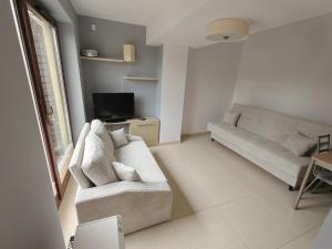 a living room with a couch and a tv at apartamenty sarbinowo in Sarbinowo