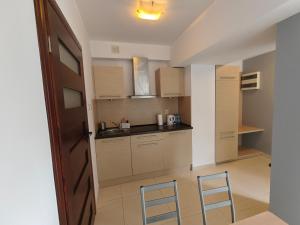 a small kitchen with two chairs and a counter top at apartamenty sarbinowo in Sarbinowo +2 photos