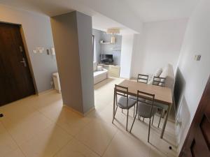 a dining room and living room with a table and chairs at apartamenty sarbinowo in Sarbinowo