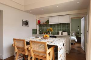 a kitchen with a table with chairs and a kitchen with a bed at Leworth Apartments, Windsor in Windsor