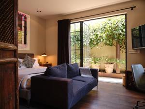 a bedroom with a bed and a couch and a window at Casa Seis Siete in Mexico City