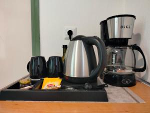 una macchinetta del caffè e una caffettiera sul bancone di Oliveland Apartments a Kávos