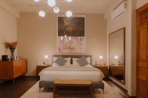 a bedroom with a large bed and a mirror at Casa Seis Siete in Mexico City