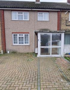 ein Haus mit einer weißen Tür und einer gemauerten Auffahrt in der Unterkunft Beautiful Tilbury House in Tilbury