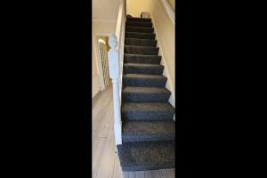 eine Treppe in einem Haus mit blauem Teppich in der Unterkunft Beautiful Tilbury House in Tilbury