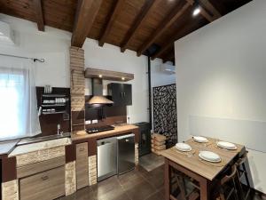 a kitchen with a wooden table and a stove top oven at Cadriano House in Granarolo dellʼEmilia
